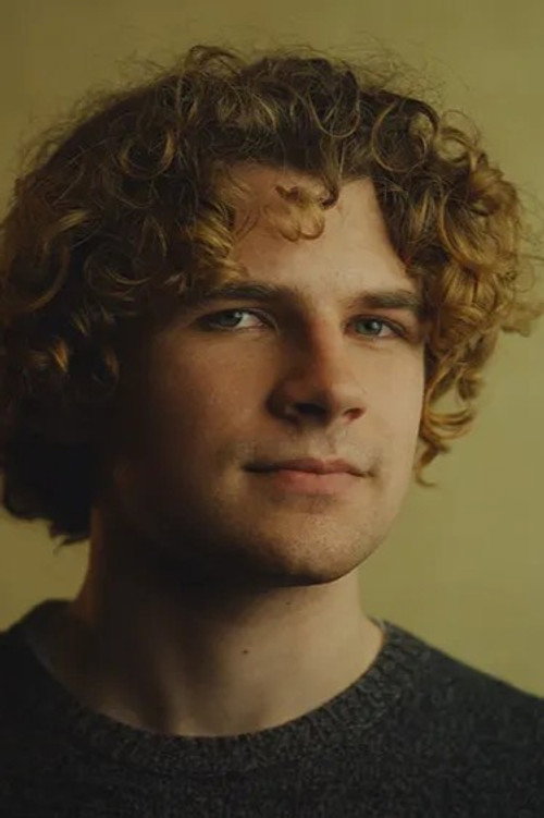 Retrato del director Kane Parsons con cabello rizado